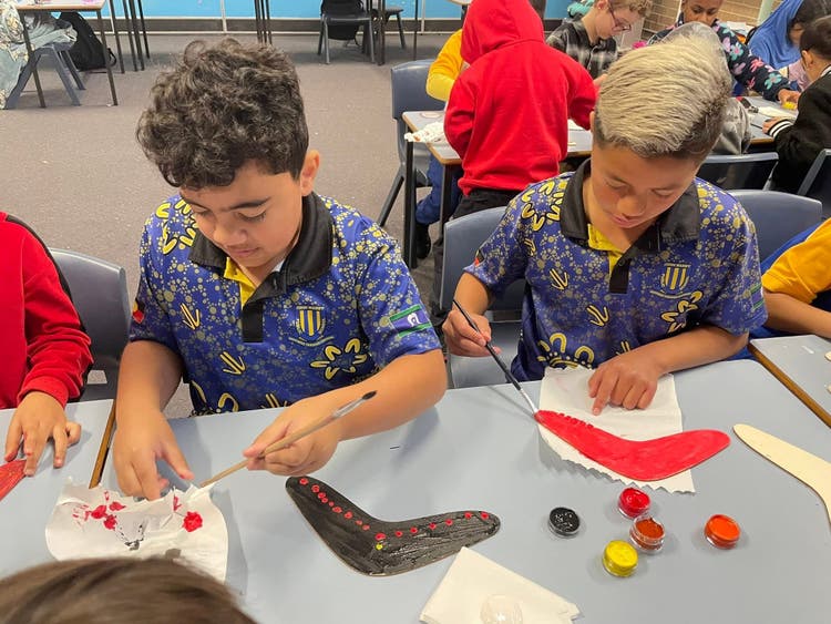 A group of students is happily creating crafts in their classroom.