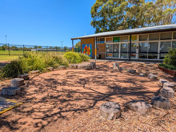 A small playground featuring a landscaped yarning circle.