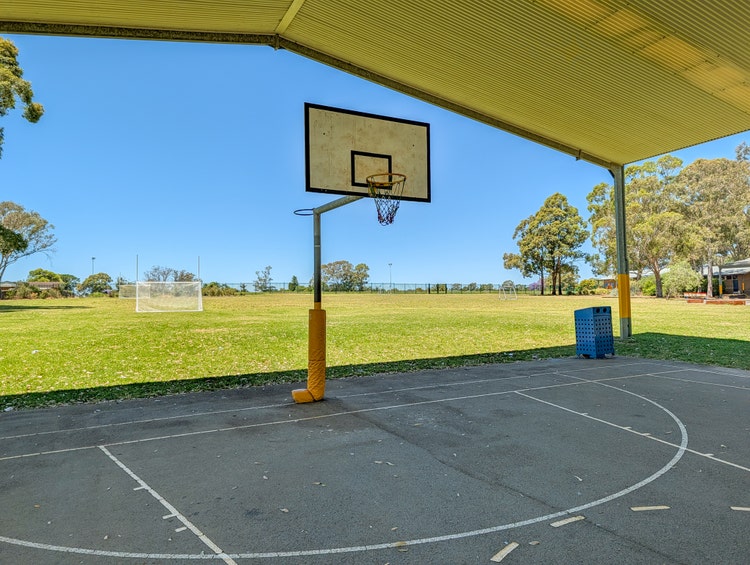 A basketball court with a hoop and net, showcasing a space for playing basketball.
